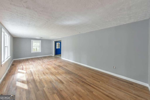 spare room featuring a textured ceiling and hardwood / wood-style floors