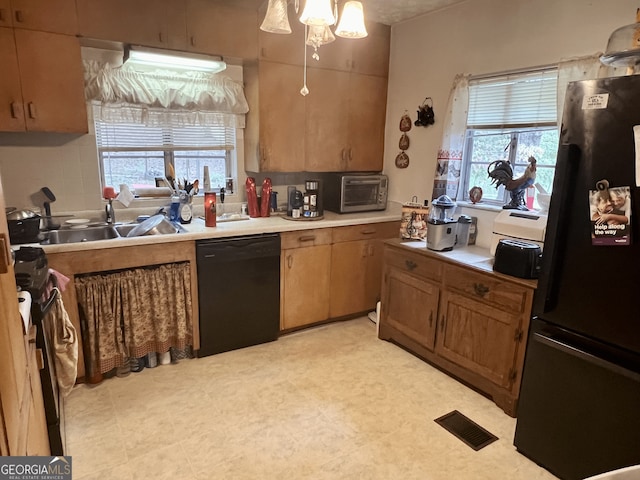 kitchen featuring pendant lighting, sink, a healthy amount of sunlight, and black appliances