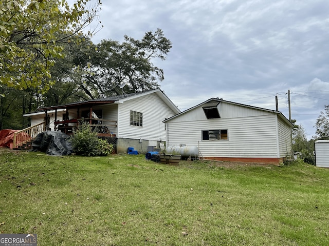 back of house with a deck and a yard