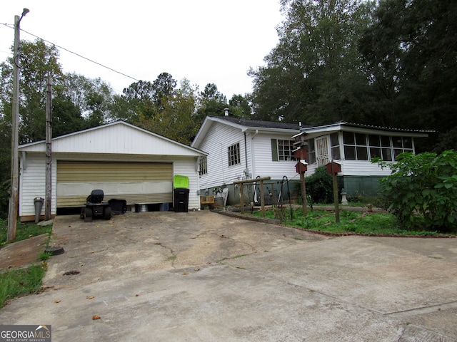 ranch-style home with a garage, a sunroom, and an outbuilding