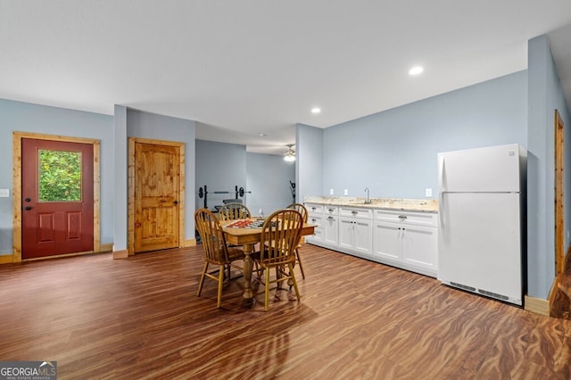 dining space with wood-type flooring, sink, and ceiling fan