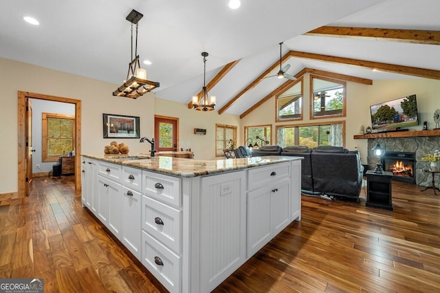 292 Silver Fox Trl, Blue Ridge, GA 30513 - kitchen with a sink, a stone fireplace, white cabinetry, light stone counters, and dark wood-style floors