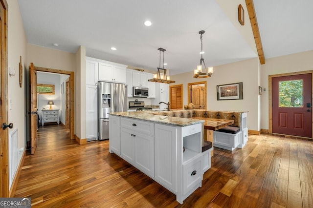 292 Silver Fox Trl, Blue Ridge, GA 30513 - kitchen featuring appliances with stainless steel finishes, hardwood / wood-style flooring, white cabinetry, an island with sink, and beamed ceiling