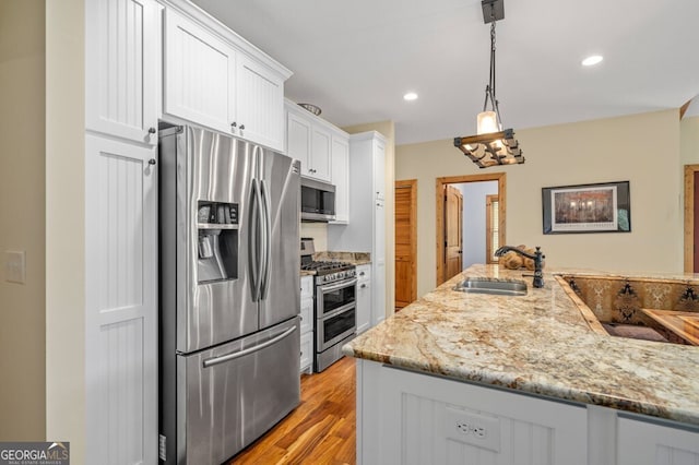 292 Silver Fox Trl, Blue Ridge, GA 30513 - kitchen featuring stainless steel appliances, a sink, white cabinetry, light stone countertops, and light wood-style flooring