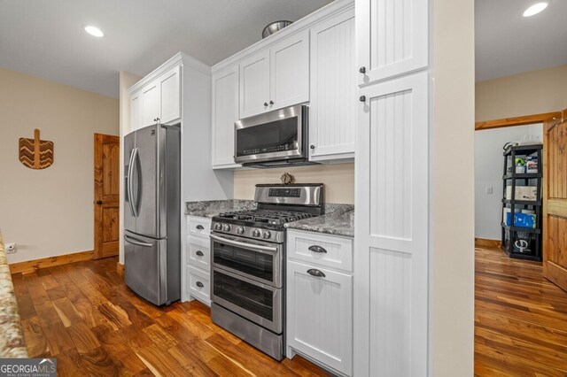 kitchen with white cabinets, stainless steel appliances, and dark hardwood / wood-style floors