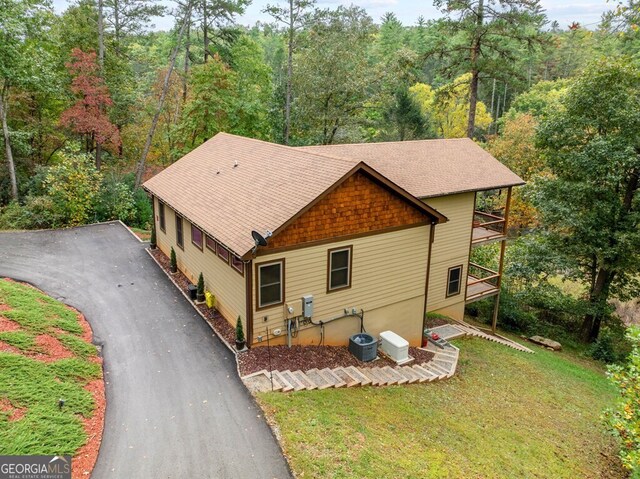 view of front of house with central air condition unit and a front yard