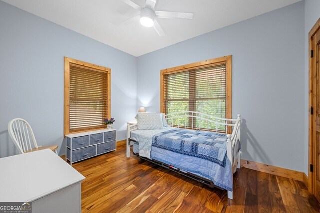 bedroom with ceiling fan and dark wood-type flooring