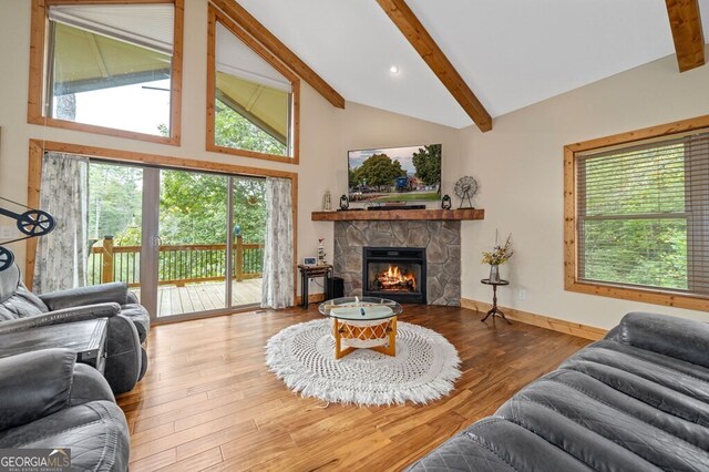 living room with vaulted ceiling with beams, a fireplace, and hardwood / wood-style floors