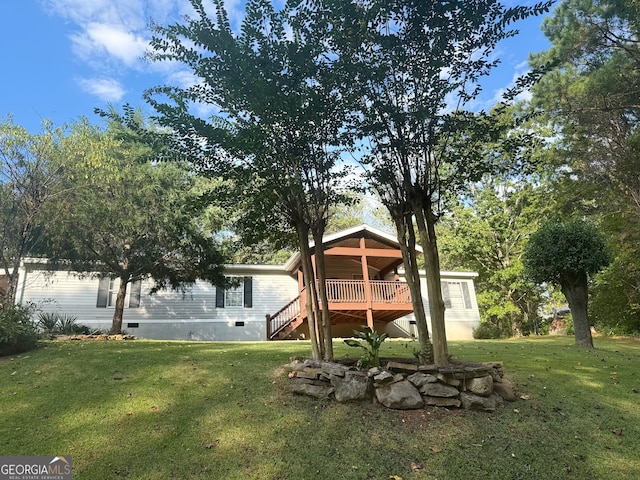 rear view of house with a yard and a deck