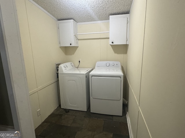 laundry area with cabinets, a textured ceiling, and washer and dryer