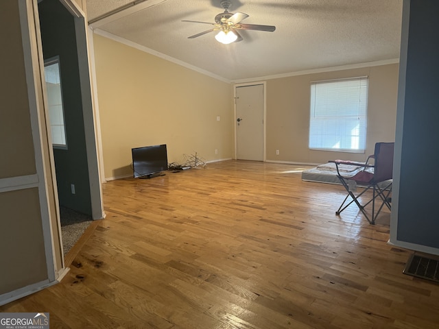 unfurnished living room with ornamental molding, a textured ceiling, hardwood / wood-style flooring, and ceiling fan