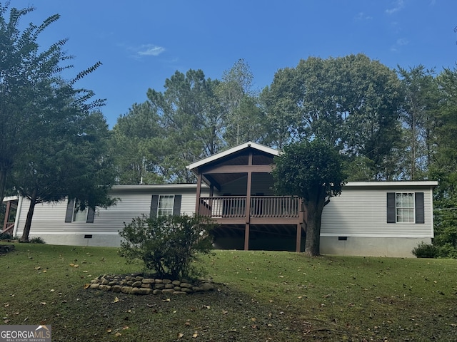 back of house with a wooden deck and a lawn