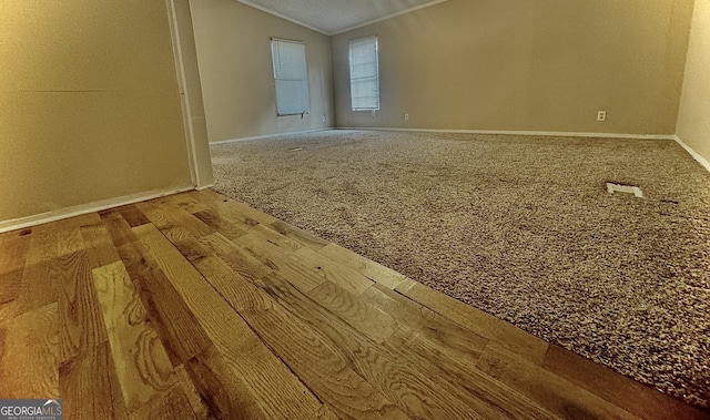 empty room with carpet floors, lofted ceiling, and crown molding