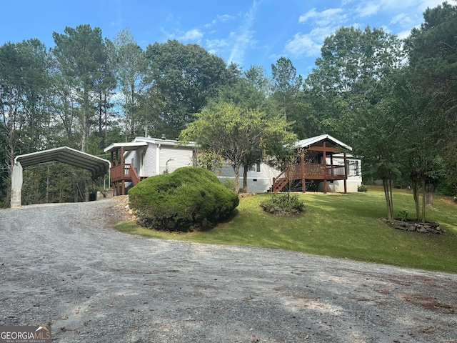 view of front facade featuring a front yard, a deck, and a carport