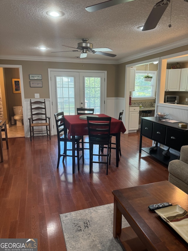 dining area featuring ceiling fan, a textured ceiling, crown molding, and dark hardwood / wood-style flooring