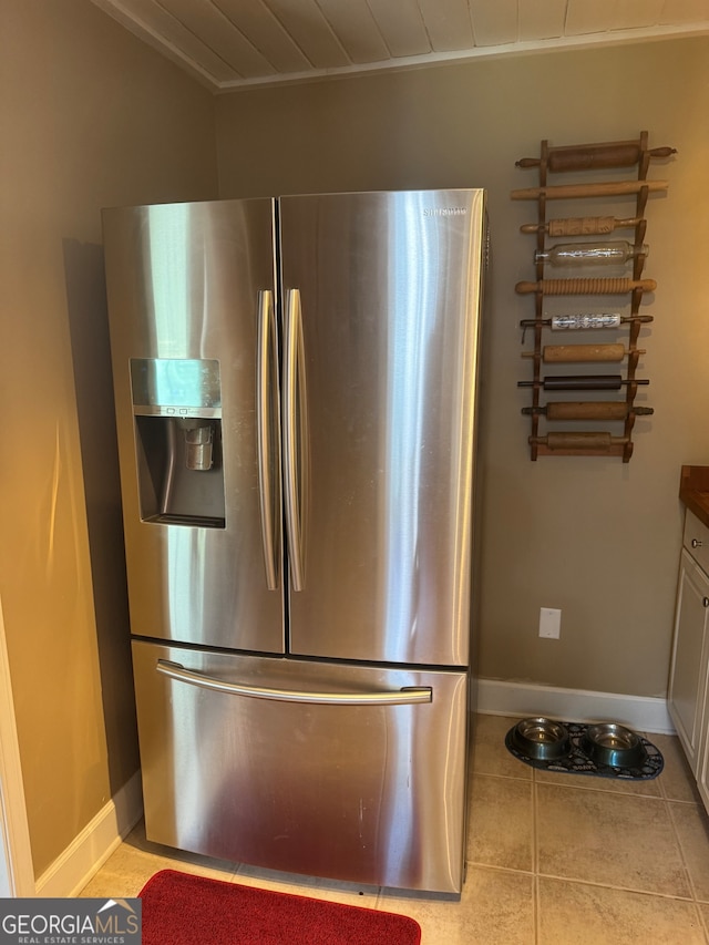 details with white cabinets, stainless steel refrigerator with ice dispenser, and light tile patterned floors