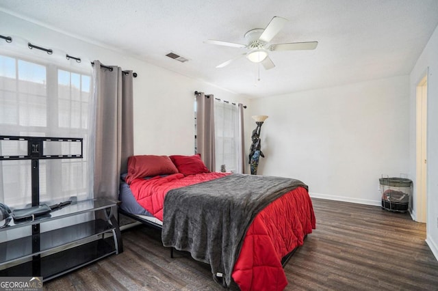 bedroom with ceiling fan, dark wood-type flooring, and a textured ceiling