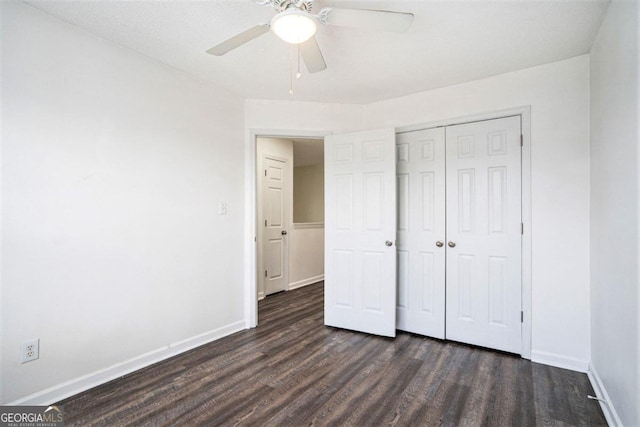 unfurnished bedroom with dark hardwood / wood-style floors, ceiling fan, and a closet