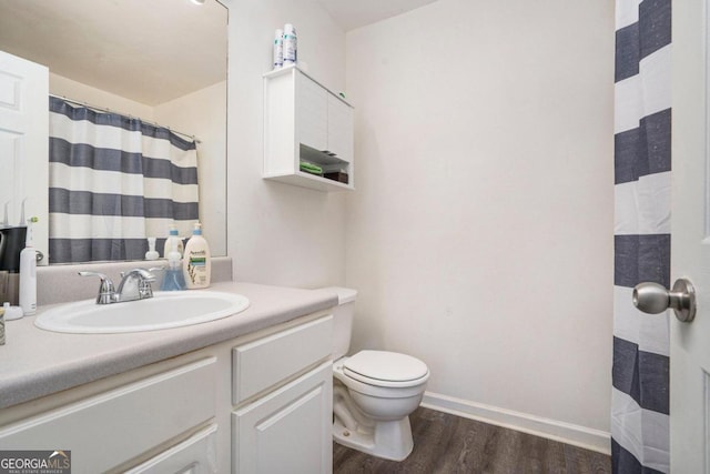 bathroom featuring wood-type flooring, vanity, and toilet