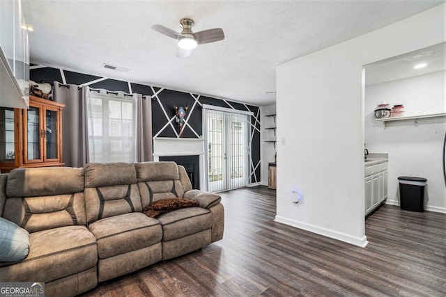 living room with a textured ceiling, dark wood-type flooring, and a wealth of natural light