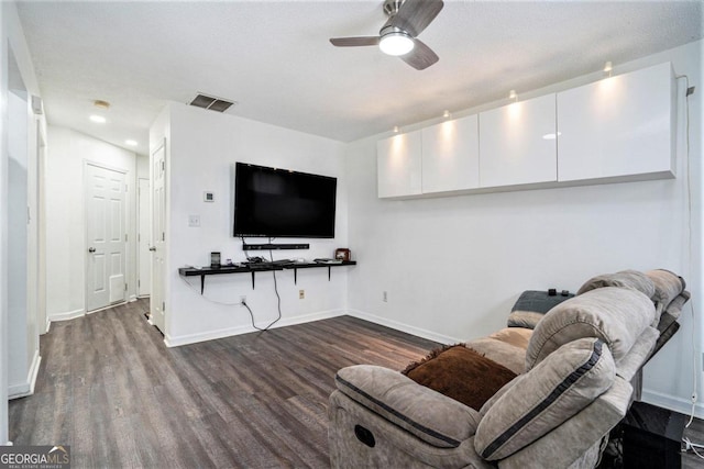 living room with a textured ceiling, dark hardwood / wood-style floors, and ceiling fan