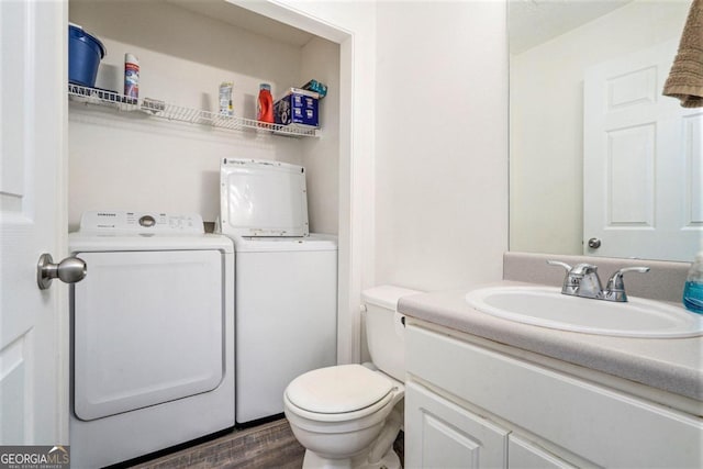 bathroom featuring vanity, hardwood / wood-style floors, separate washer and dryer, and toilet