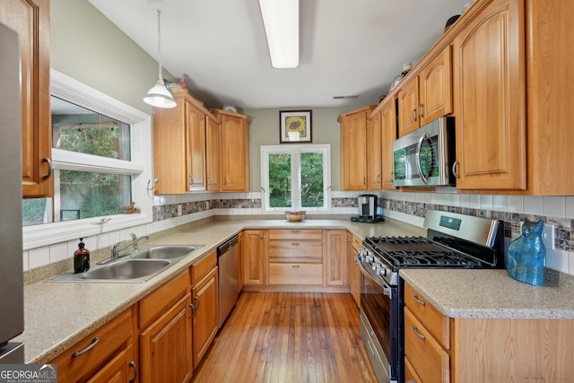 kitchen featuring a healthy amount of sunlight, light hardwood / wood-style floors, sink, and stainless steel appliances