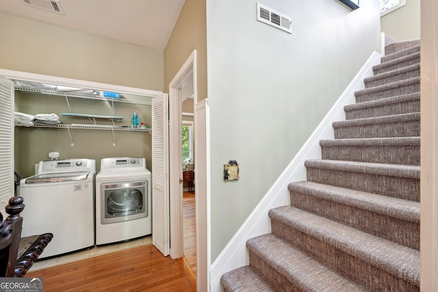 laundry room featuring separate washer and dryer and light hardwood / wood-style floors