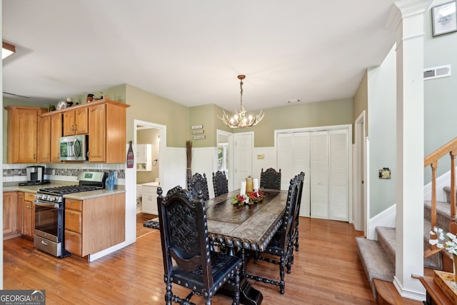 dining area with light wood-type flooring and a chandelier