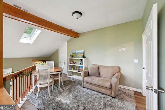 sitting room featuring wood-type flooring and lofted ceiling with skylight