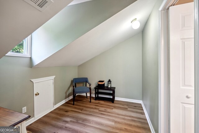 sitting room featuring light wood-type flooring and vaulted ceiling