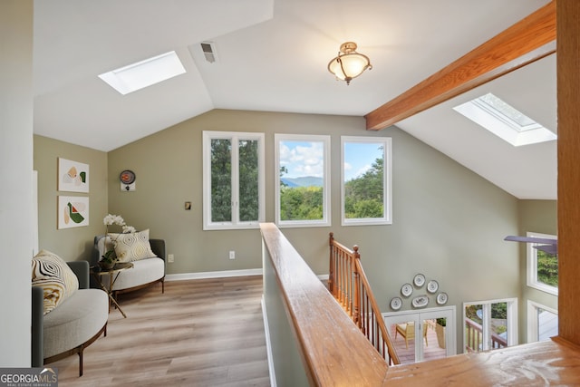 interior space featuring vaulted ceiling with beams and light wood-type flooring