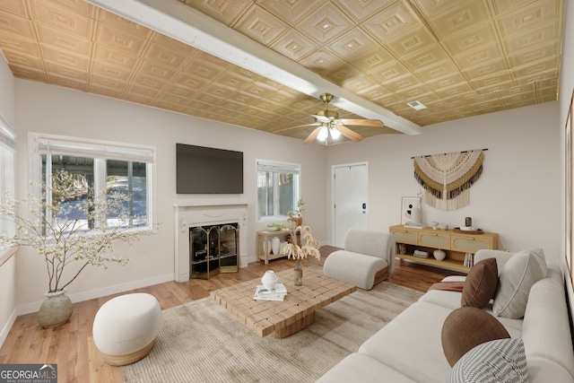 living room featuring a premium fireplace, hardwood / wood-style flooring, plenty of natural light, and ceiling fan