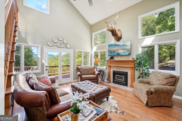 sunroom featuring lofted ceiling, a tiled fireplace, and plenty of natural light