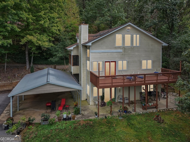 back of property with a wooden deck and a patio area