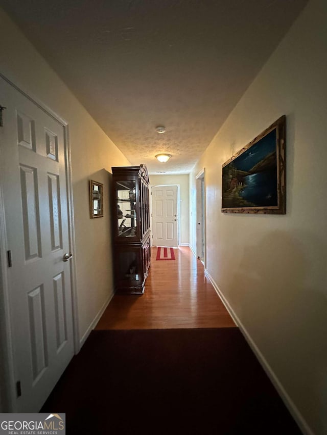 corridor with hardwood / wood-style flooring