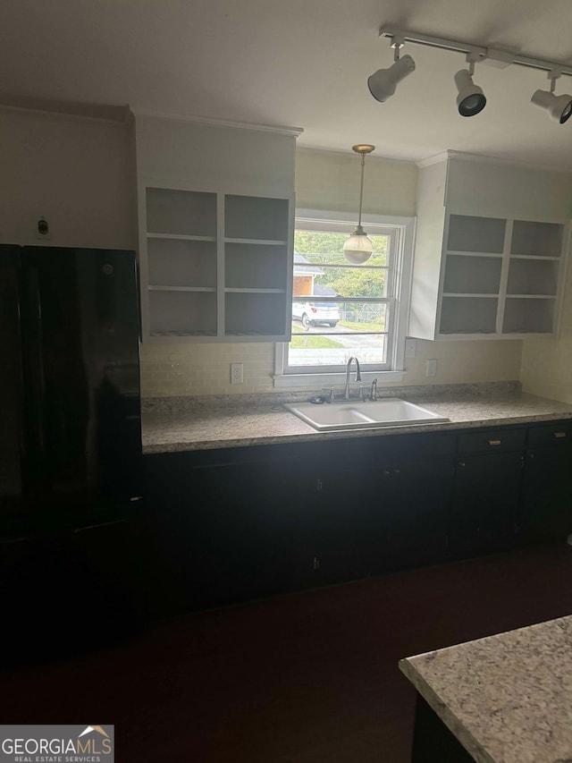 kitchen featuring decorative light fixtures, sink, and rail lighting