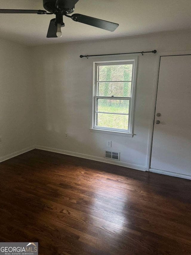 spare room with ceiling fan and dark wood-type flooring