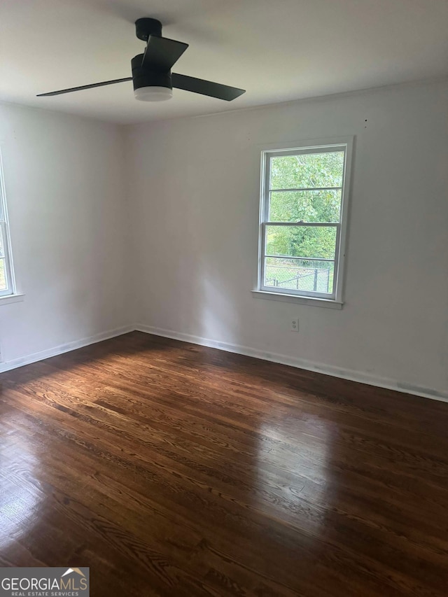 empty room featuring ceiling fan and dark hardwood / wood-style flooring