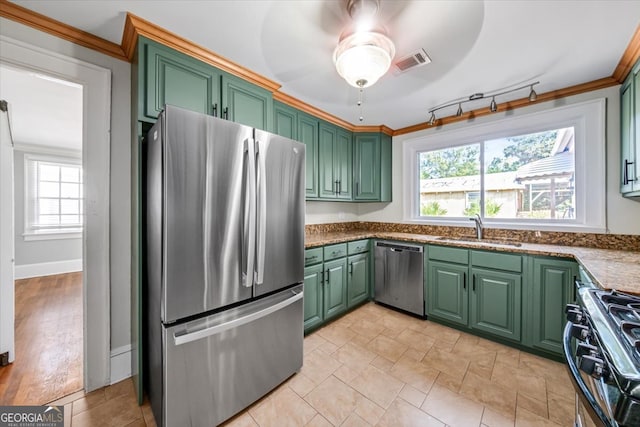 kitchen featuring appliances with stainless steel finishes, crown molding, sink, and a healthy amount of sunlight