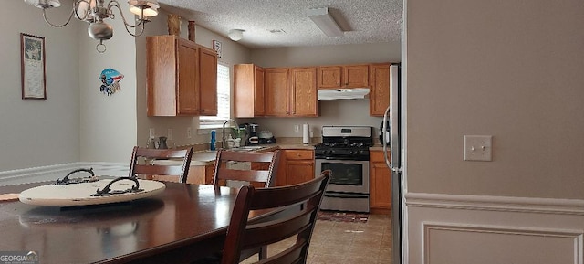 3364 Joseph Dr NW, Acworth, GA 30101 - kitchen featuring under cabinet range hood, gas range, a sink, a textured ceiling, and light countertops