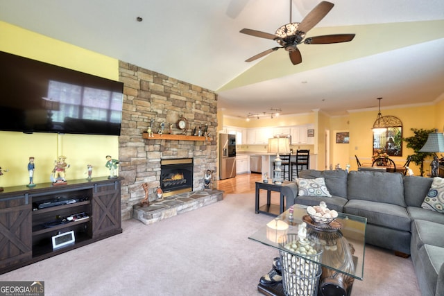 carpeted living room with ornamental molding, vaulted ceiling, ceiling fan, and a fireplace