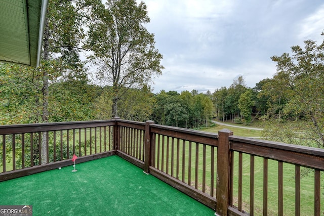 wooden deck featuring a lawn