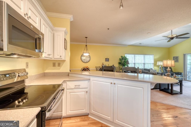 kitchen with white cabinets, stainless steel appliances, and light hardwood / wood-style flooring