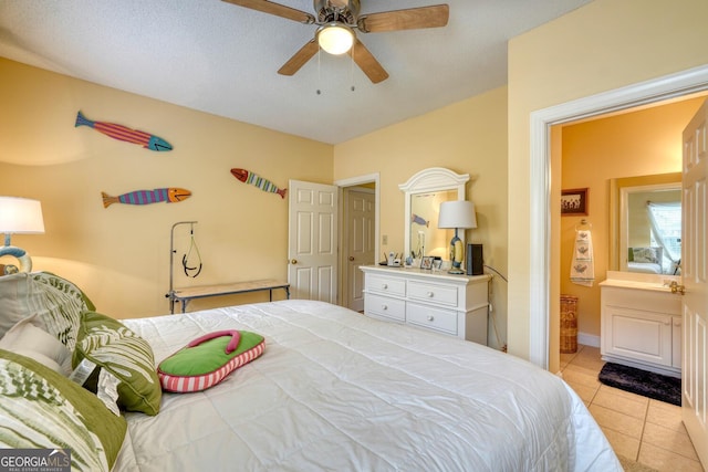 tiled bedroom with ceiling fan and a textured ceiling