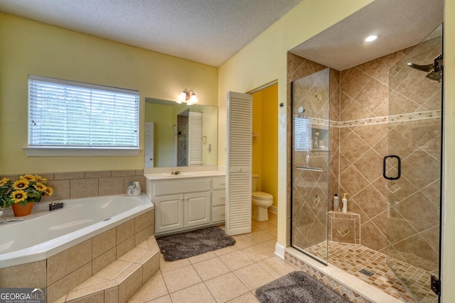 full bathroom featuring vanity, a textured ceiling, tile patterned floors, shower with separate bathtub, and toilet