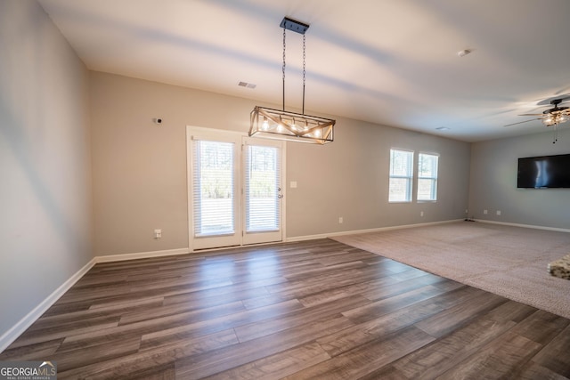 spare room featuring dark hardwood / wood-style floors, ceiling fan, and a wealth of natural light