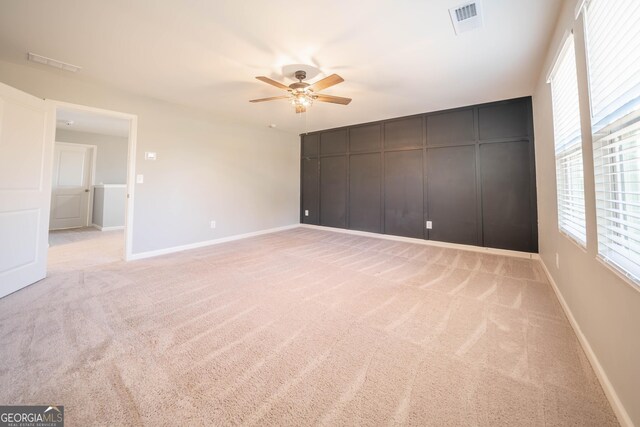 spare room with light carpet and ceiling fan