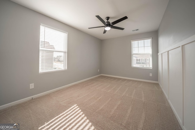 carpeted spare room with ceiling fan