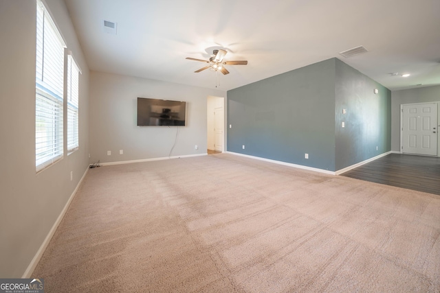 carpeted spare room featuring ceiling fan